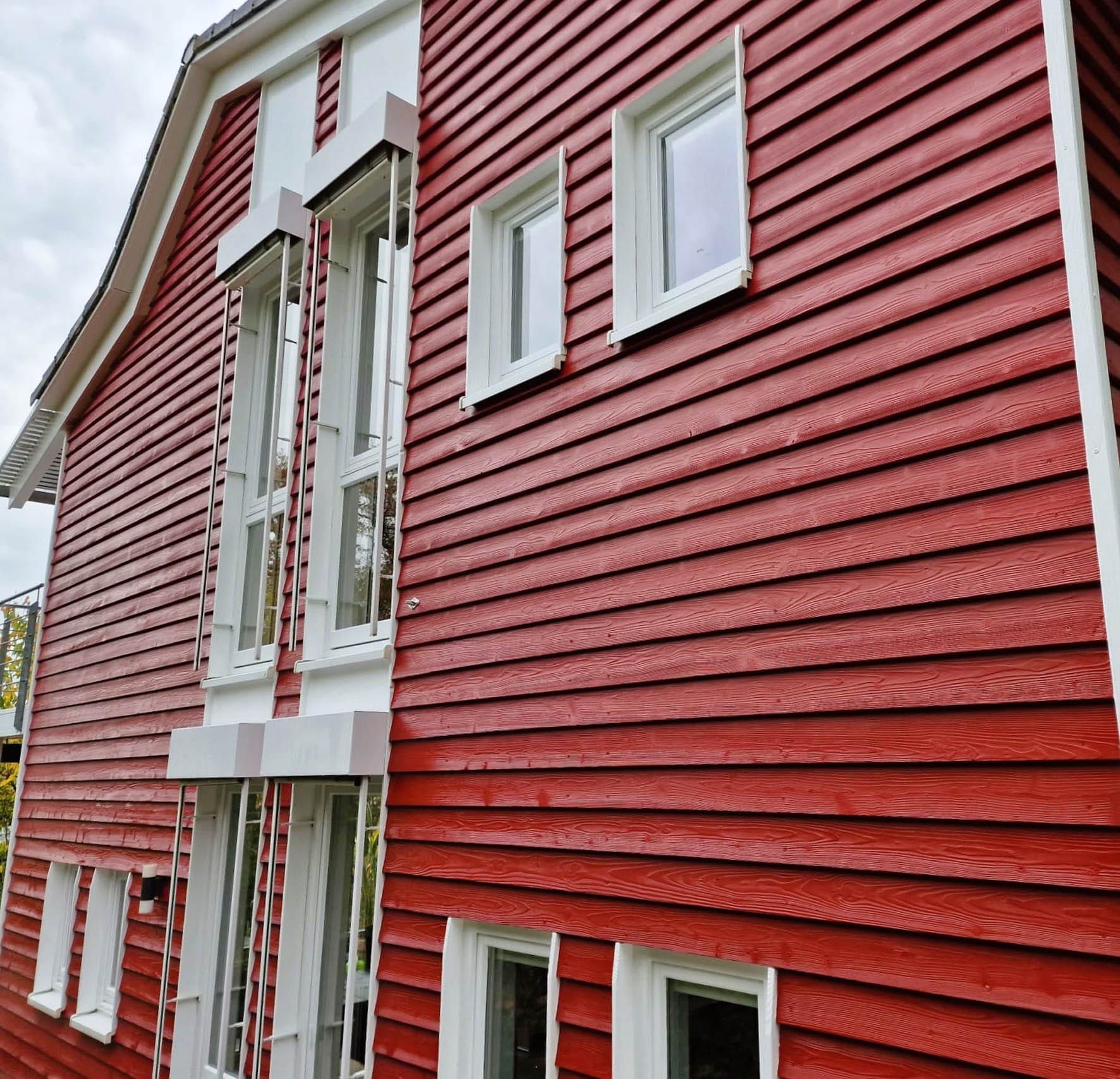Rotes Holzhaus mit großen Fenstern