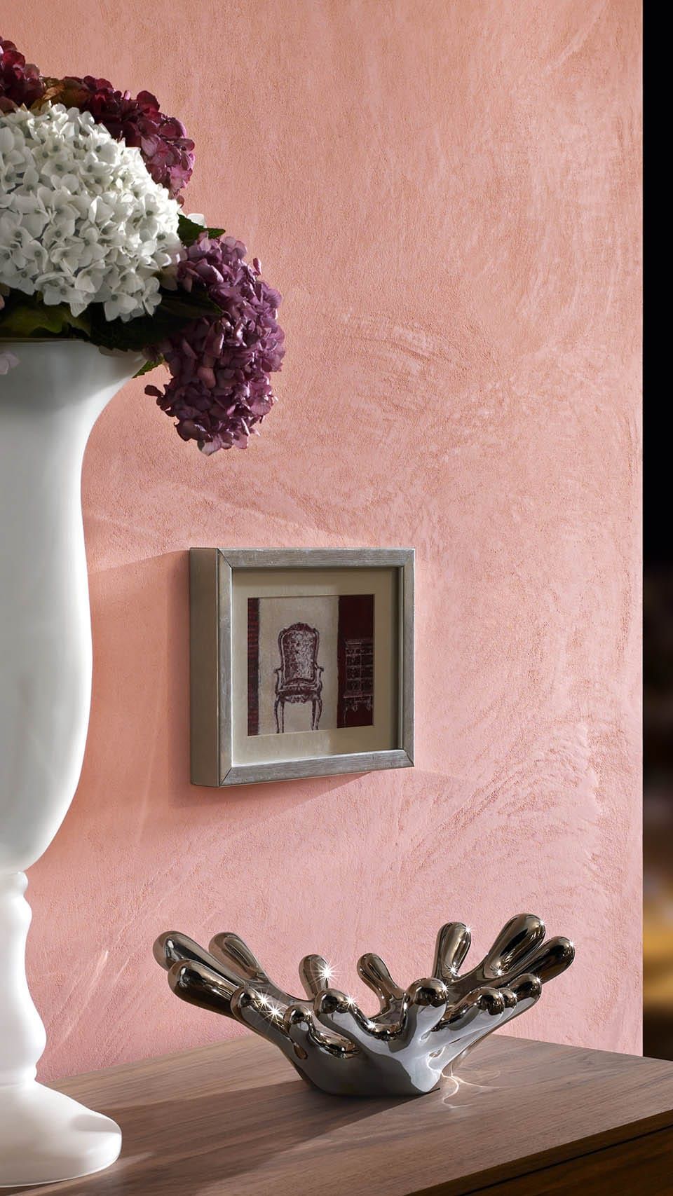 Vase mit Blumen neben einem gerahmten Bild
