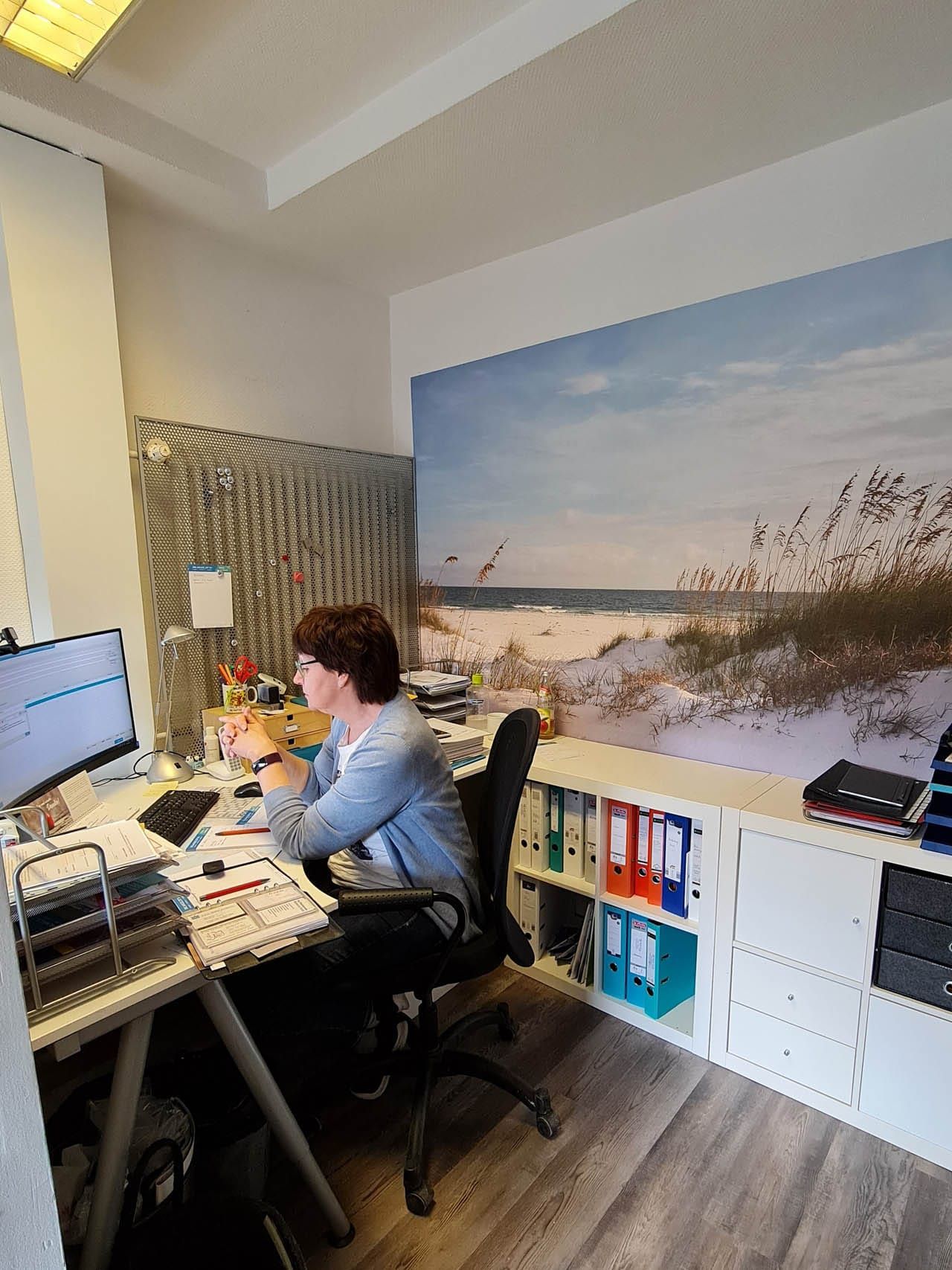 Frau arbeitet an Schreibtisch im Büro.