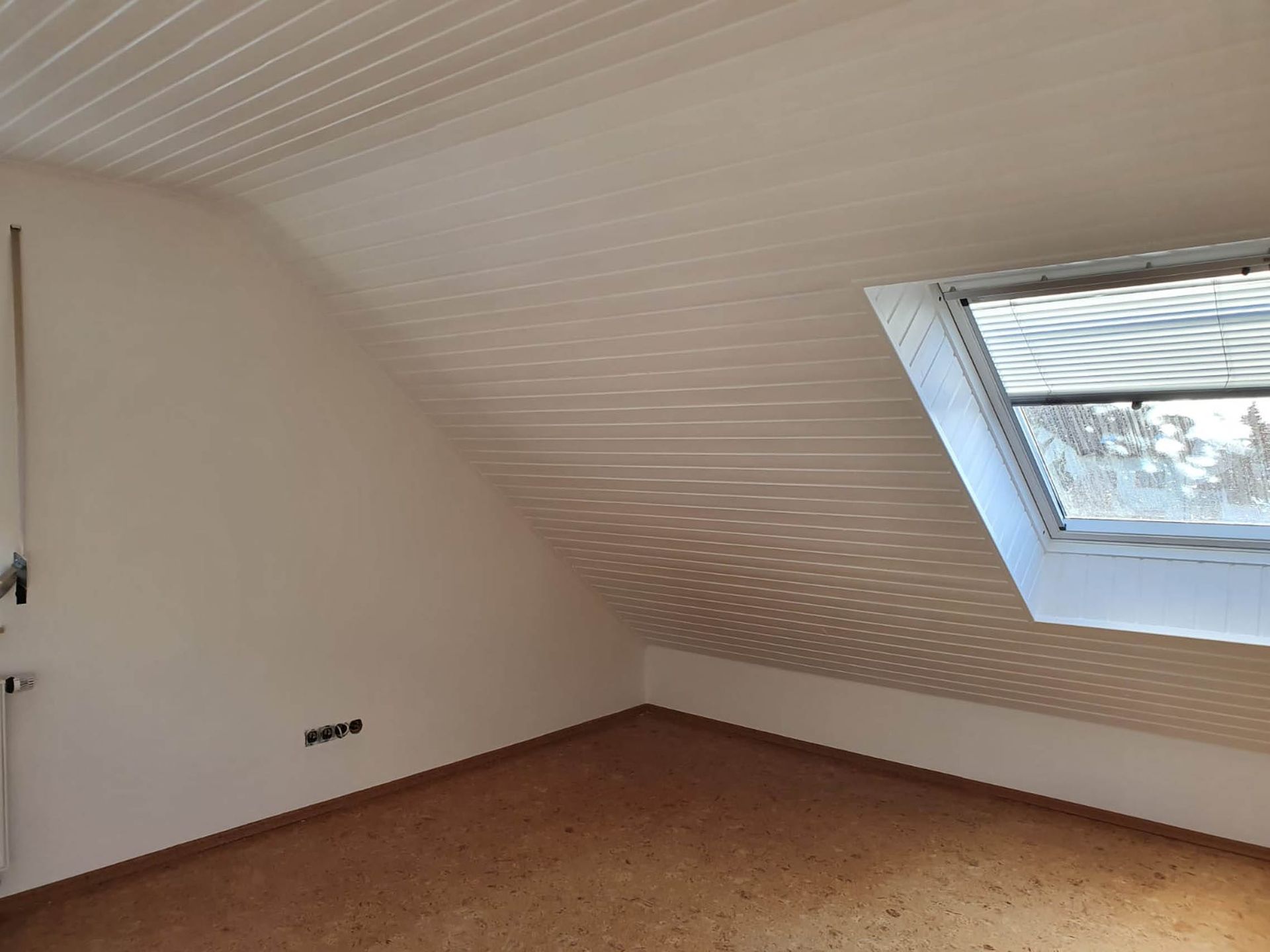 Heller Dachraum mit Fenster und Holzboden