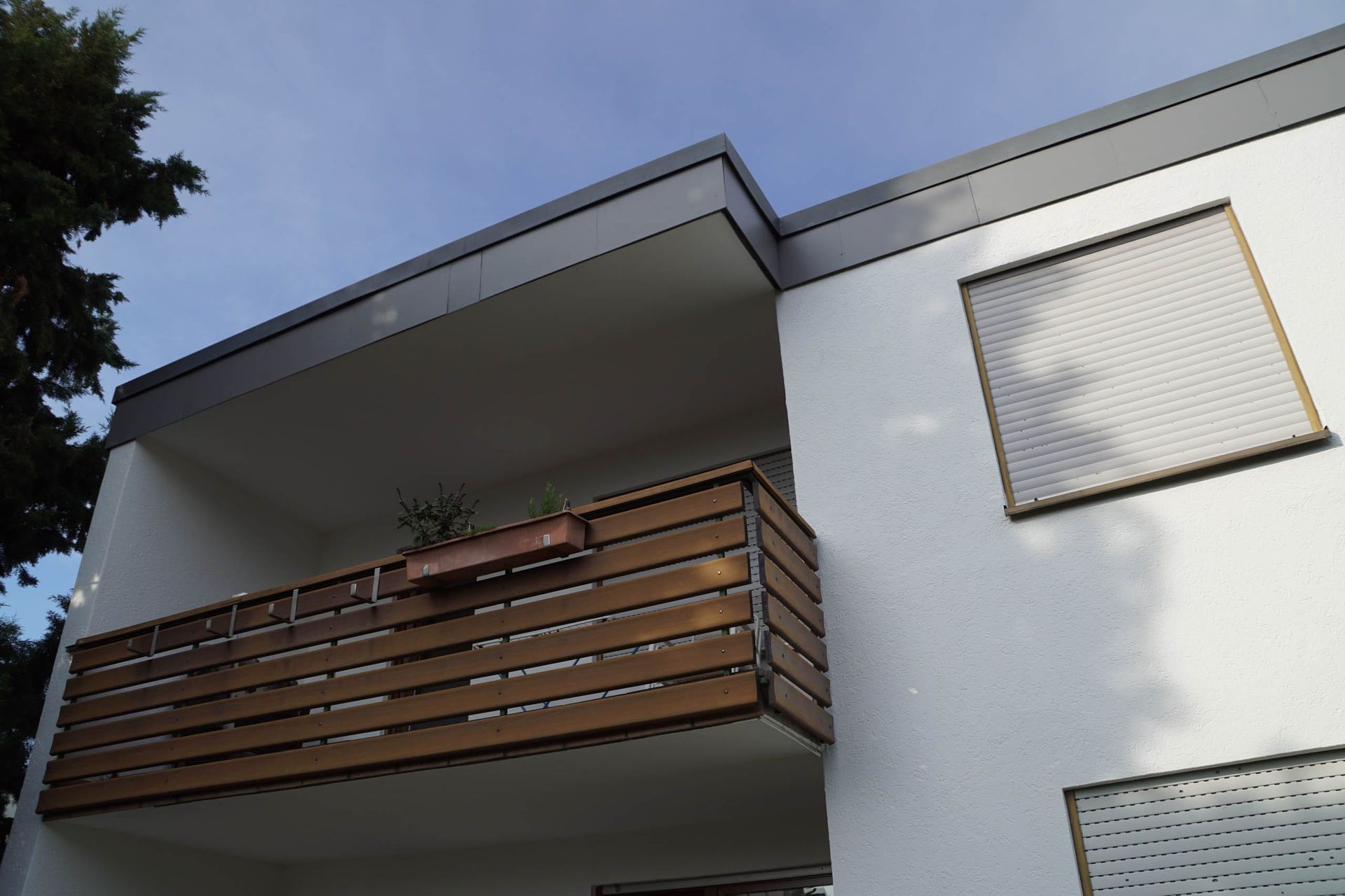 Modernes Gebäude mit Balkon und Pflanzen.