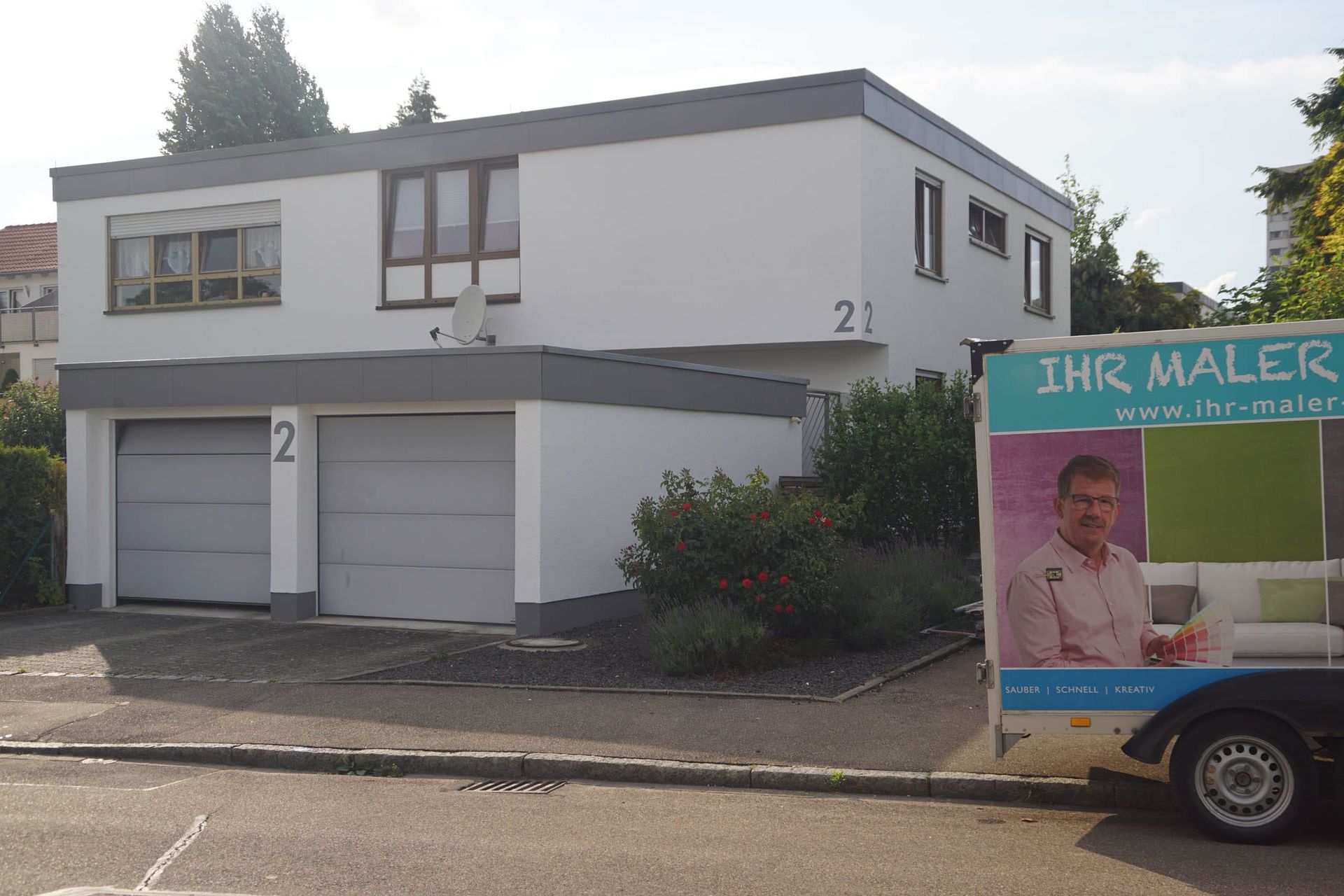 Helles Wohnhaus mit Garagen und Rosenbeeten
