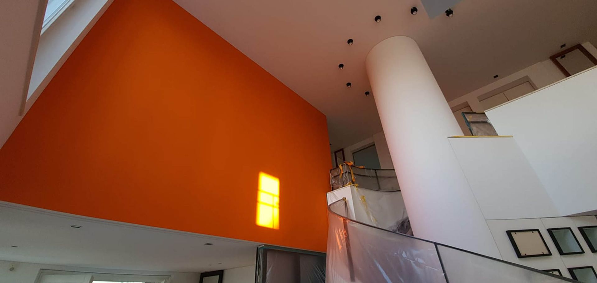 Raum mit orangefarbener Wand und Säule.