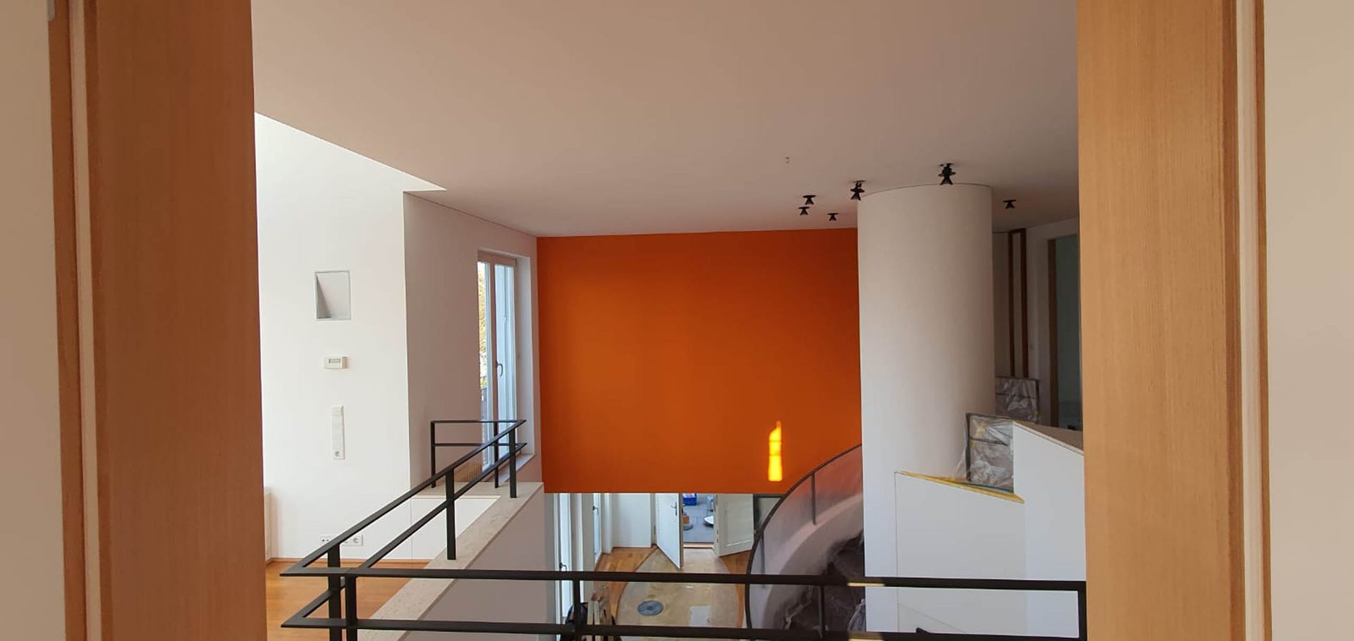 Moderne Wohnung mit orangefarbener Wand und Geländer