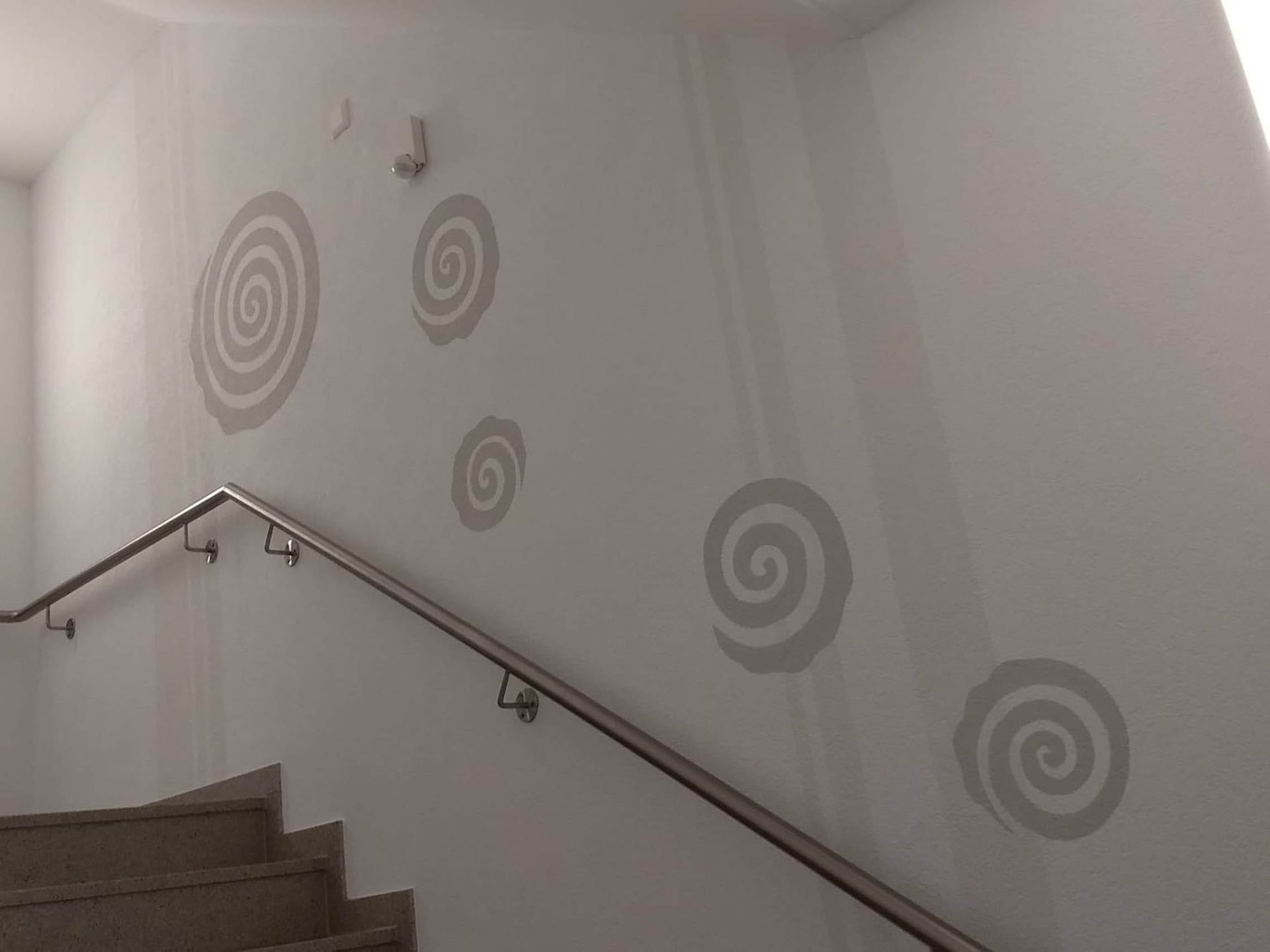 Wand mit spiralförmigen Mustern und Treppe