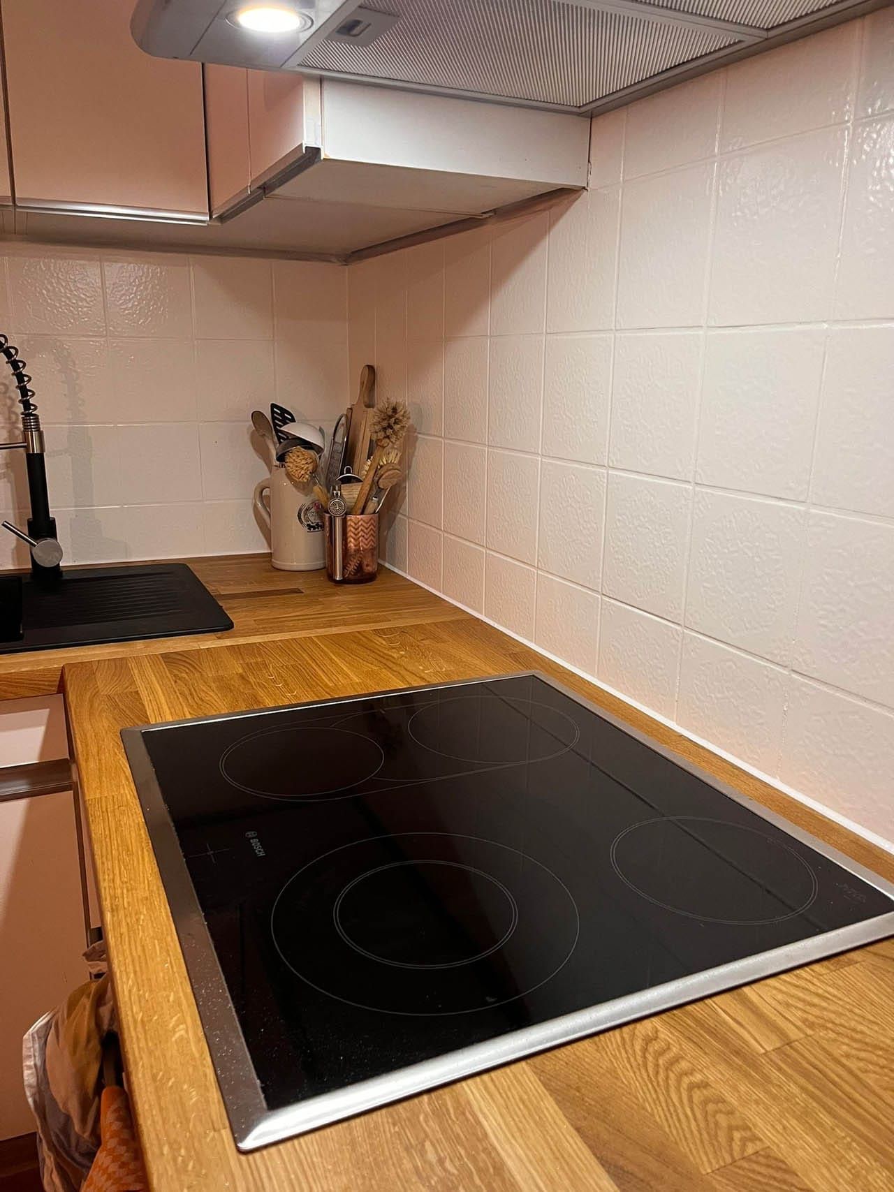 Moderne Küche mit glaskeramischem Kochfeld und Utensilien