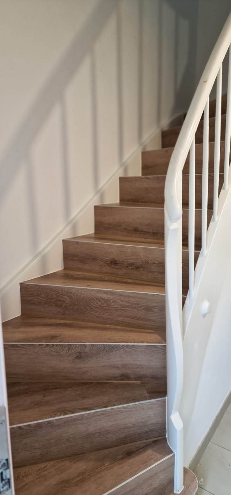 Holztreppe mit weißen Geländer und Schatten