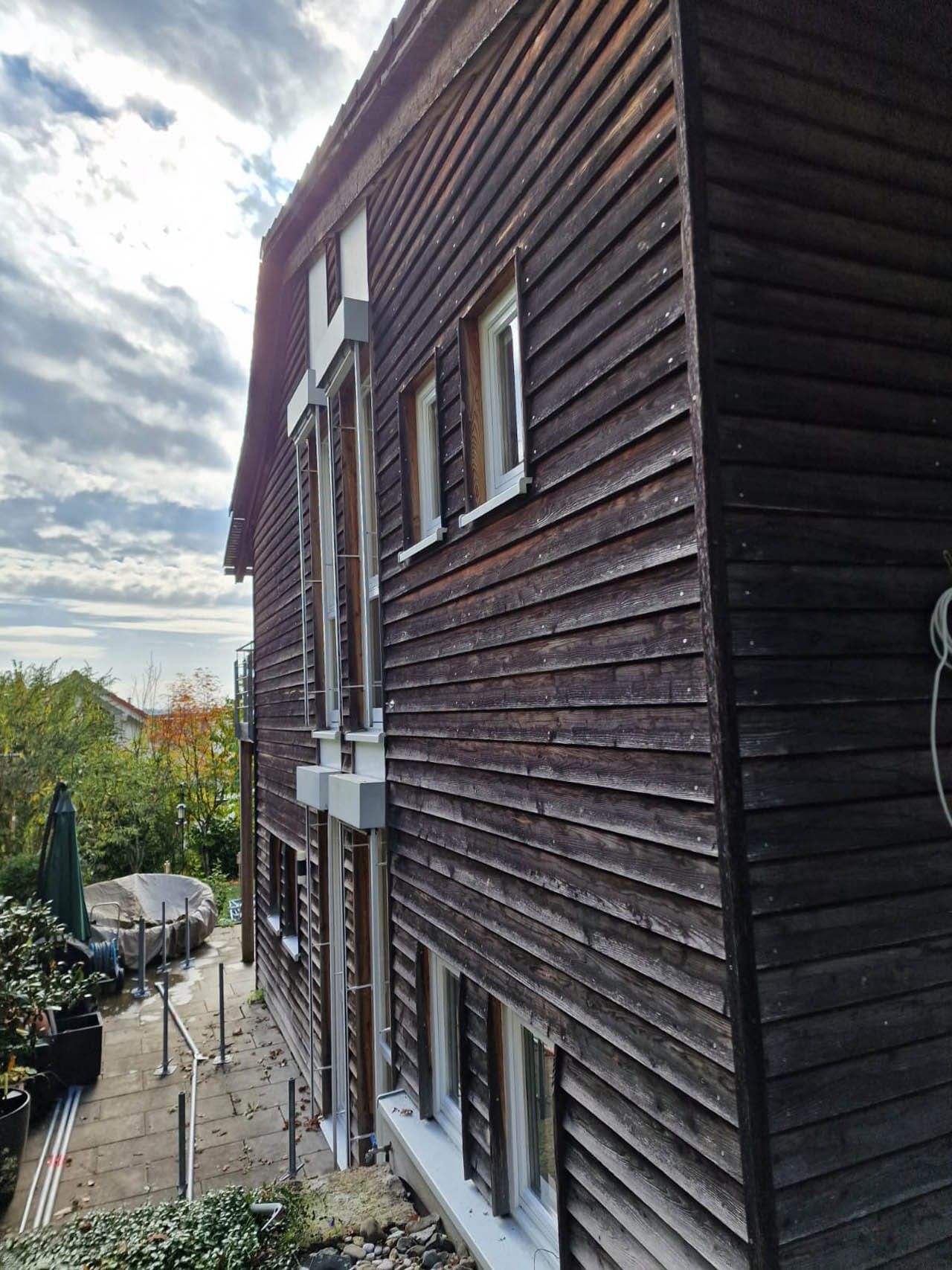 Vorher: Holzhaus mit Fenstern und Gartenbereich.