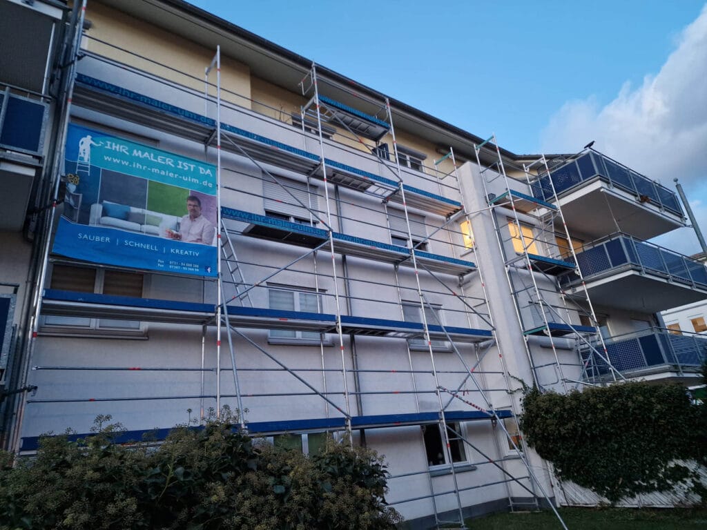 Hausfassade mit Gerüst und Werbebanner