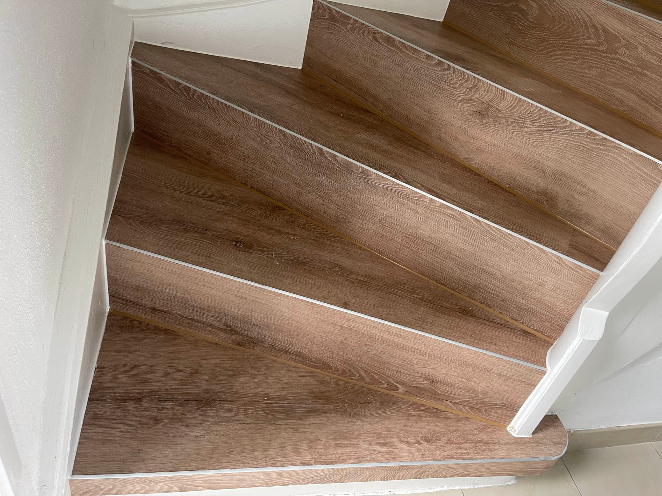 Holztreppe mit Weißabgrenzungen im Innenbereich