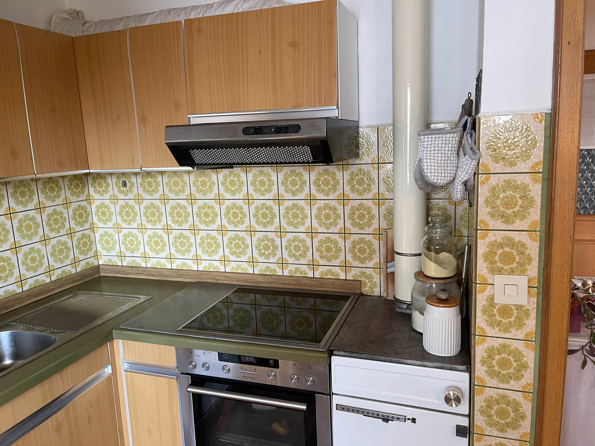Moderne Küche mit grünem Herd und blumigen Fliesen